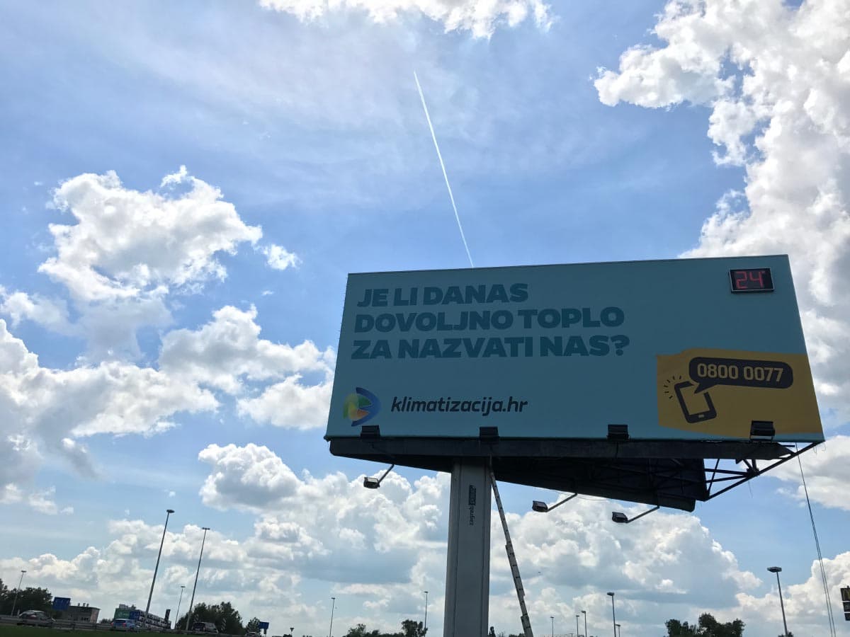 LED brojčani prikaz temperature (24°) ugrađen na vrh reklamnog billboarda uz cestu
