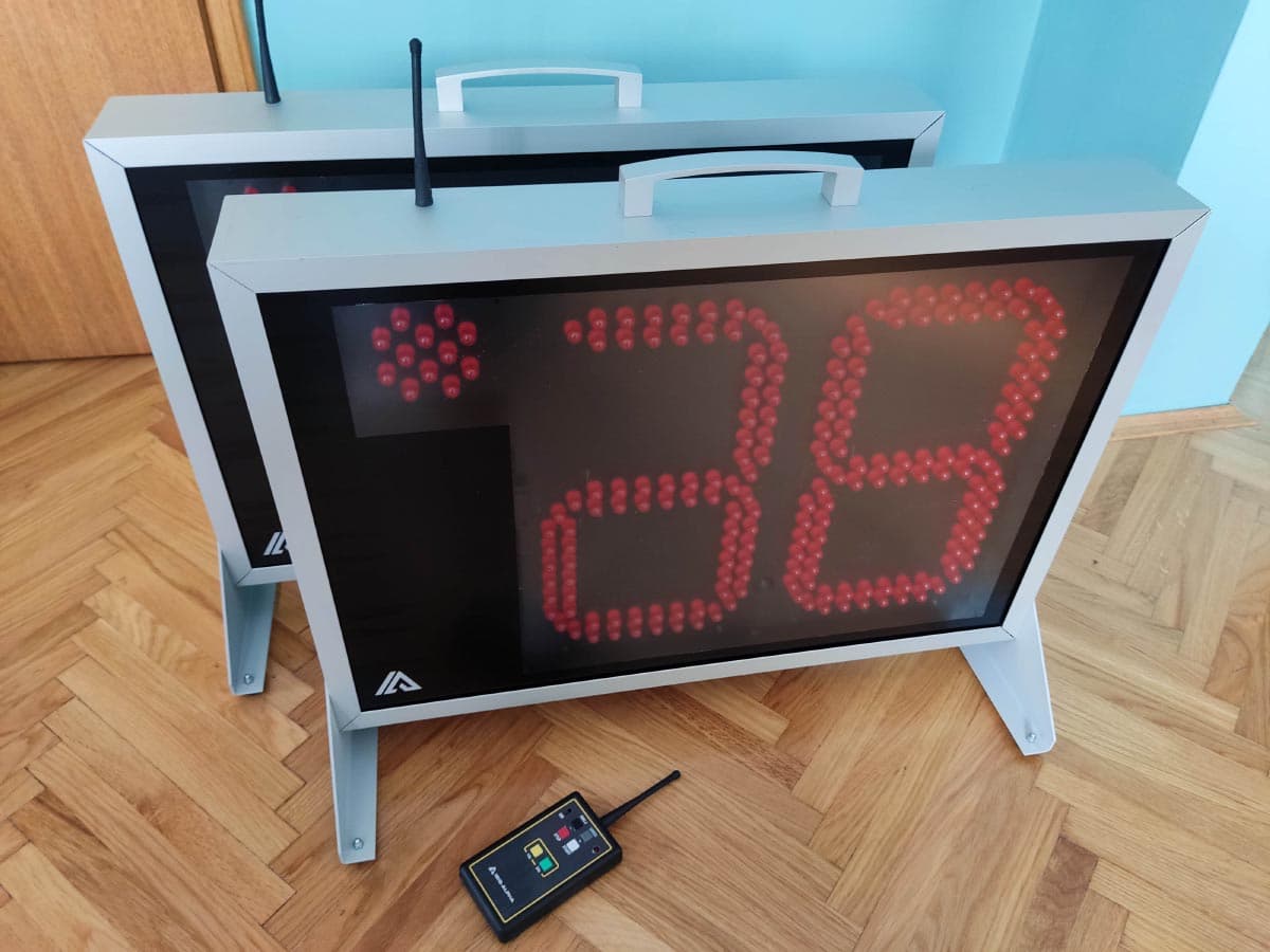 Dva prijenosna semaforska uređaja s ručkama i antenama na parket podu