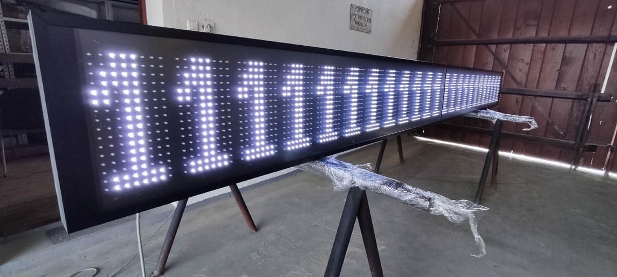 LED display panel s nizom brojki, snimljen iz kuta u radioničkom prostoru