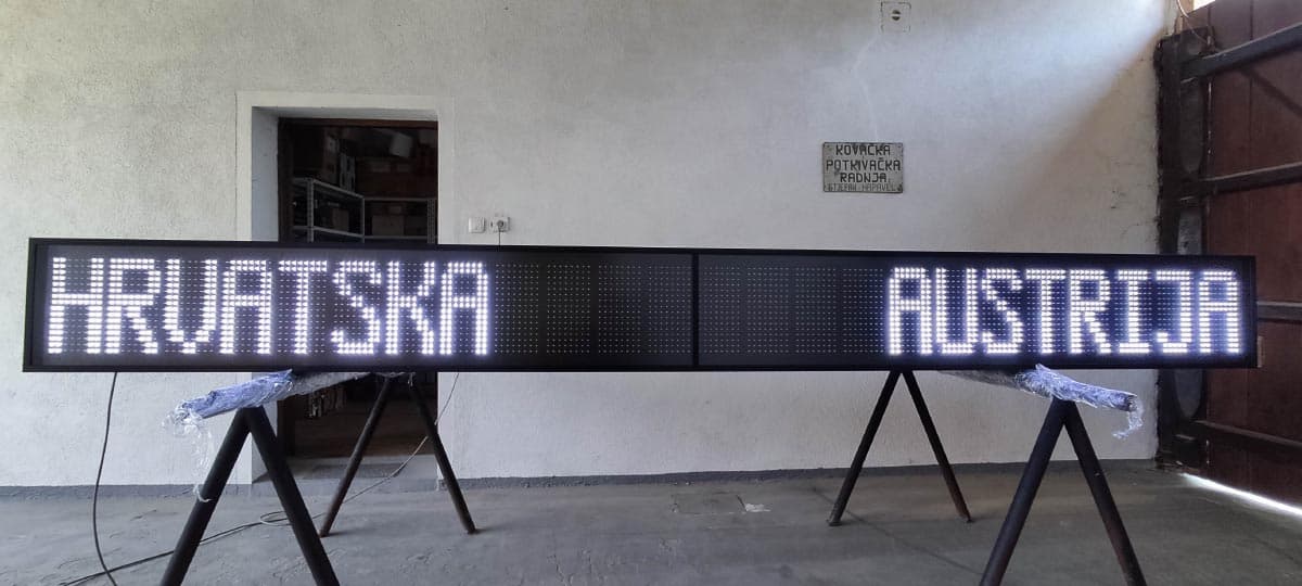 LED display panel s ispisanim nazivima dviju država, u istom radioničkom prostoru