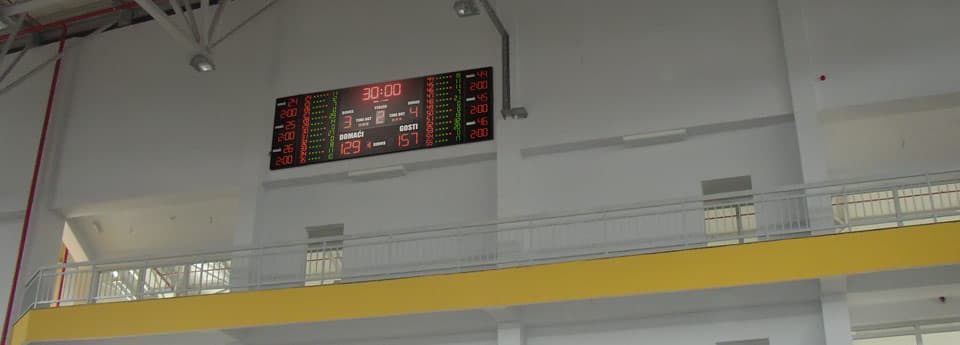 Semafor visoko na zidu dvorane s galerijom i žutom gredom u prvom planu